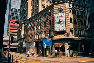 People on street against buildings in city