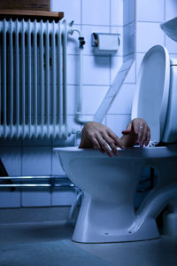 Midsection of man sitting in bathroom