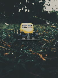 Close-up of yellow toy car on field