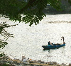 People sitting on boat and fishing against river