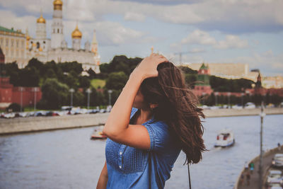 Woman standing in city against sky