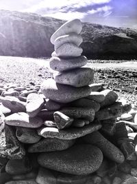 Stack of pebbles on beach against sky