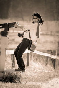 Woman by coin-operated binoculars on field