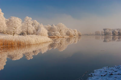 Scenic view of lake against sky during winter