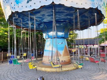 Swing ride in park against sky