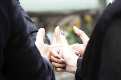 Cropped image of friends gesturing thumbs up