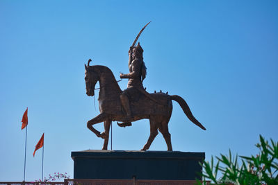 Low angle view of statue against clear blue sky