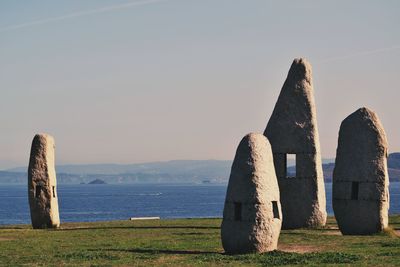 Gazebo on rock in sea against clear sky