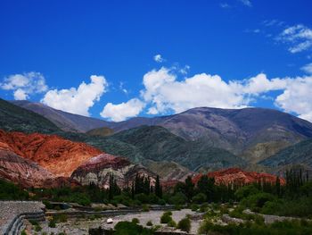 Panoramic view of landscape and mountains against blue sky