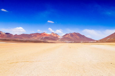 Scenic view of desert against blue sky