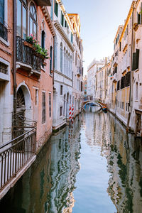 Canal amidst buildings against sky