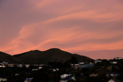 Houses in town against sky during sunset