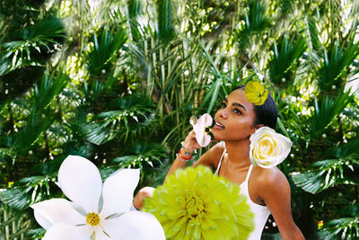 Cuban young woman in a garden surrounded by white and yellow flowers