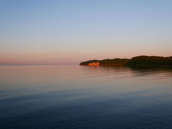 Scenic view of sea against clear sky at sunset