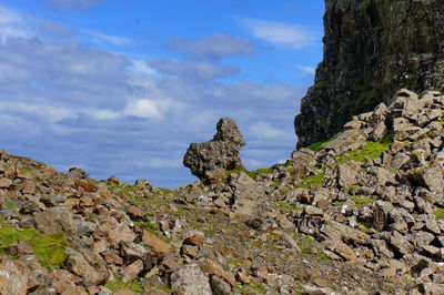 Scenic view of cliff by sea against sky