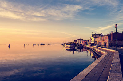 Pier over sea against sky during sunset