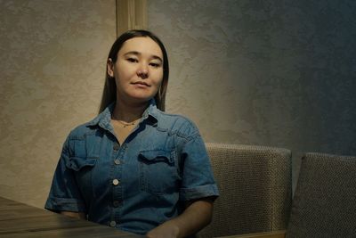 Portrait of a beautiful young woman sitting on sofa at home