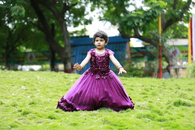 Girl holding purple flower on field