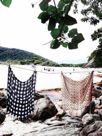 Clothes drying on beach against clear sky