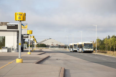 Road sign at airport against sky