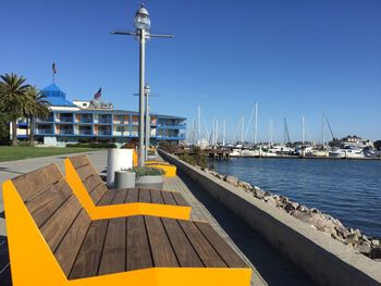 Sailboats moored at harbor against clear blue sky