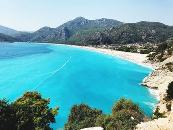 Scenic view of sea and mountains against sky