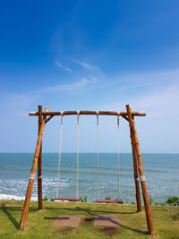 Wooden swing with tropical sea background. freedom and holidays concept.
