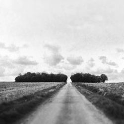 Dirt road passing through field