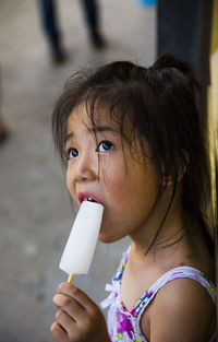 Cute girl eating ice cream outdoors