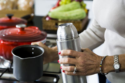 Midsection of senior woman holding containers