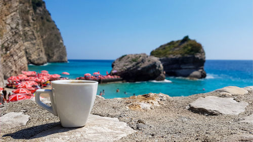 Cup of coffee on background of beautiful sea landscape with picturesque sea, beach 