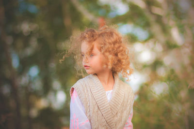 Close-up of young woman against trees