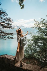 Woman looking at lake against sky