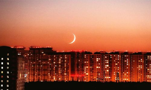 Illuminated buildings against sky at night