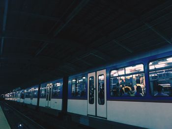 Train at illuminated railroad station platform at night