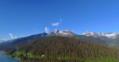 Scenic view of snowcapped mountains against blue sky