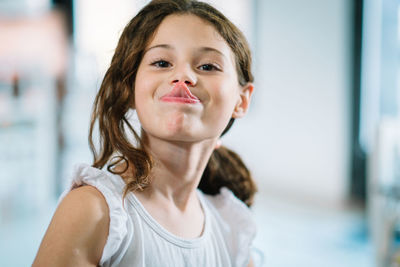 Portrait of little girl sticking out her tongue