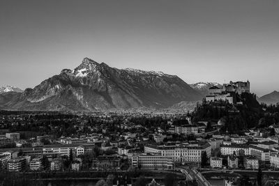 Townscape by mountain against clear sky