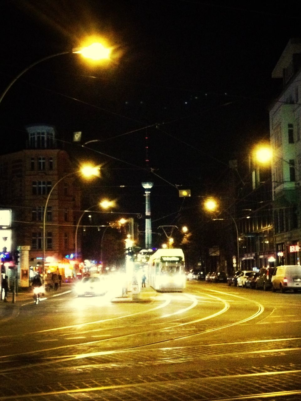 illuminated, night, building exterior, city, street, architecture, car, land vehicle, built structure, street light, city street, transportation, motion, city life, mode of transport, road, lighting equipment, incidental people, long exposure, sky