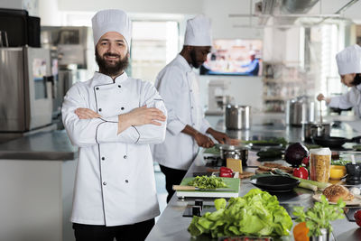 Happy chef standing in commercial kitchen