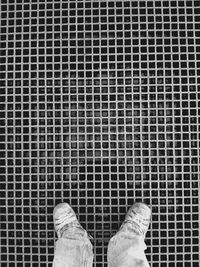Low section of person standing on tiled floor