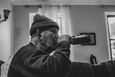 Portrait of man holding camera at home