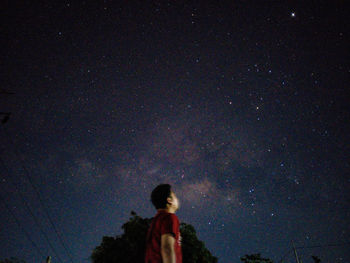 Low angle view of silhouette people standing against sky at night