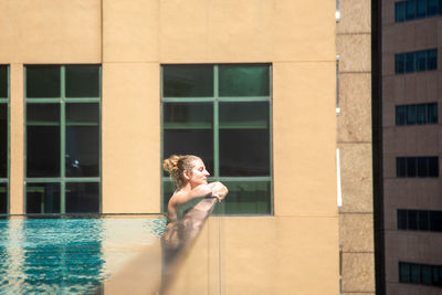 Full length of shirtless man in swimming pool against building