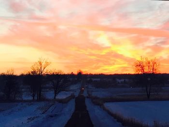 Snow covered field at sunset