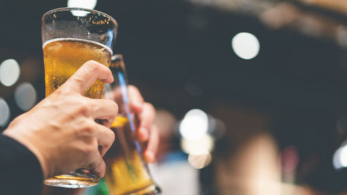 Close-up of hand holding beer glass