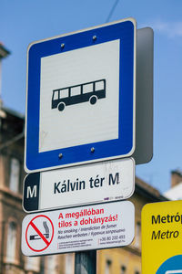 Low angle view of road sign against blue sky