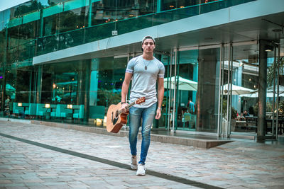 Full length portrait of smiling man walking in city