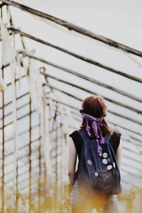 Low angle view of woman standing with backpack