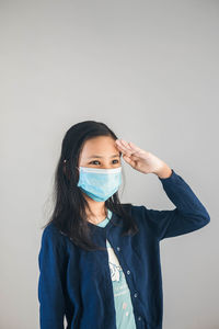 Portrait of young woman standing against white background